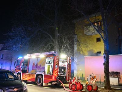 Ein Löschfahrzeug mit Blaulicht vor dem Brandobjekt